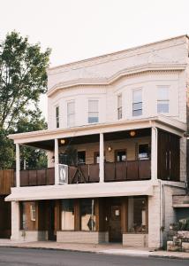 a white building with a sign on the front of it at guesthouse by good neighbor in Baltimore