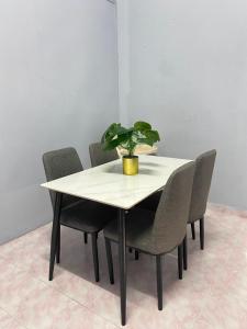 uma mesa com cadeiras e um vaso de plantas sobre ela em RUMAH INAP 09 em Arau