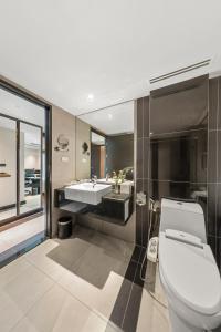 a bathroom with a toilet and a sink at Golden Tulip Mandison Suites in Bangkok