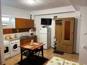 a small kitchen with a table and a refrigerator at OGADUGU in Bucharest