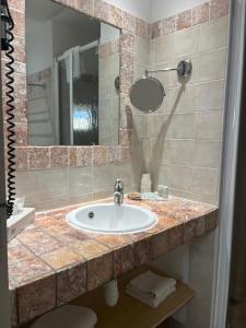 y baño con lavabo y espejo. en Hôtel Lilium Maris, en Tizzano