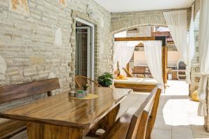ein Esszimmer mit einem Holztisch und Bänken in der Unterkunft Villa Pietro Comfortable holiday residence in Čabrunići