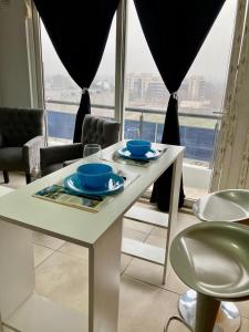 a white table with two blue dishes on it in front of a window at 7-Exclusivo monoambiente en Moron centro in Morón