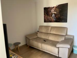 uma sala de estar com um sofá e uma pintura na parede em Apartamento puerto em A Guarda