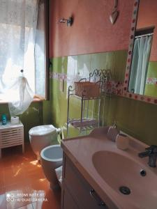 y baño con lavabo, aseo y espejo. en lety.home appartamento incantevole vicino al mare, en Rosignano Marittimo