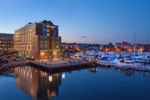 Residence Inn by Marriott Boston Harbor on Tudor Wharf في بوسطن: المارينا في الليل مع القوارب في الماء