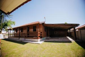 ein Holzhaus mit einem Rasenhof davor in der Unterkunft Recanto Figueirinha in Jaguaruna
