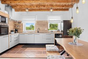 a kitchen with white cabinets and a wooden table at Villa Pietro in Čabrunići