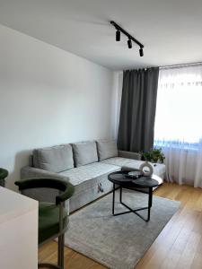 uma sala de estar com um sofá e uma mesa em Apartman 306 em Lukavica