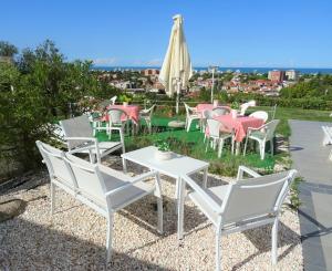 a group of chairs and tables and an umbrella at B&B Cá Bianca Ventisette Riccione in Riccione