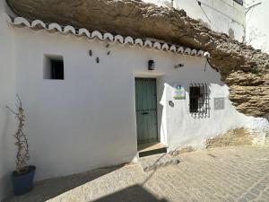 a white building with a door and a wall at Tajito Romano in Setenil