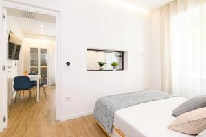 a white bedroom with a bed and a table at Modern & Elegant by NDP Rent - NDP Rent in Rome