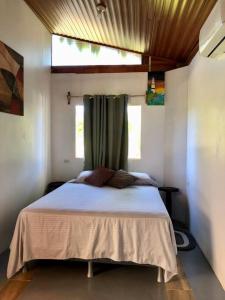 a bedroom with a white bed with a window at Cabaña Puerto Carrillo (Santa Marta) in Hojancha