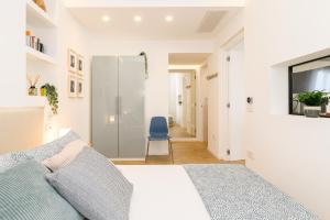 a bedroom with a bed and a blue chair at Modern & Elegant by NDP Rent - NDP Rent in Rome