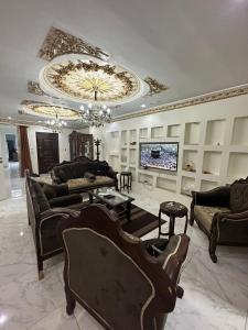 sala de estar amplia con sofás y TV en شقةفندقيةمفروشة على الدائري في القاهرة, en El Cairo