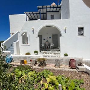 a white house with an archway in a yard at Panagiotis Rooms in Naousa