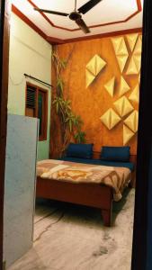a bedroom with a bed with paper paintings on the wall at OYO 81311 Blue Moon In in Auraiya