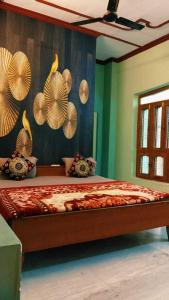 a bedroom with a bed with fans on the wall at OYO 81311 Blue Moon In in Auraiya