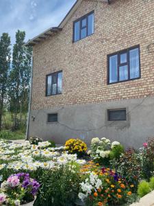a garden of flowers in front of a brick building at Guest House Ayara in Kyzyl-Tuu +14 photos