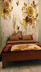 a bedroom with a bed with flowers on the wall at OYO 81311 Blue Moon In in Auraiya