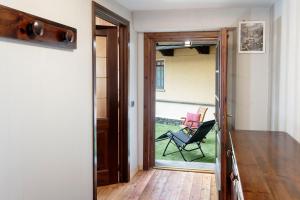 an open door leading to a patio with a chair at HelloChalet - Maison Maquignaz with boot-warmer, 100m skibus in Valtournenche
