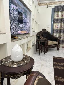 sala de estar con TV, sofá y mesa en شقةفندقيةمفروشة على الدائري في القاهرة, en El Cairo