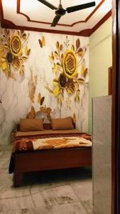 a bedroom with a bed with flowers on the wall at OYO 81311 Blue Moon In in Auraiya