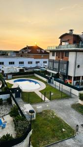 un gran edificio con piscina en un patio en Atico Duplex con terraza en Santander, en Santa Cruz de Bezana