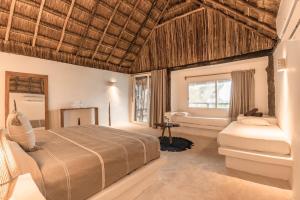 um quarto com uma cama e uma banheira em Niken Beachfront Tulum Hotel em Tulum