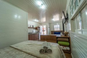 a large white room with a bed and a kitchen at Chalés da Tribo in Bom Jardim da Serra