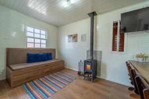 a room with a bed and a wood stove at Chalés da Tribo in Bom Jardim da Serra