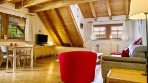 a living room with a red chair and a table at Haus Miriam in Münstertal