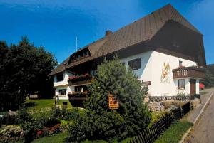 ein großes weißes Gebäude mit einem schwarzen Dach in der Unterkunft Pension Schmidt - Schwarzwaldnest - voll ausgestattetes Apartment in Häusern