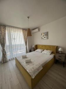 um quarto com uma cama grande e uma janela grande em Апартамент за гости “Диана” em Burgas