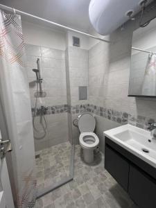uma casa de banho com um chuveiro, um WC e um lavatório. em Апартамент за гости “Диана” em Burgas