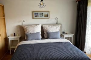 een slaapkamer met een groot bed met 2 nachtkastjes bij Gemütliche Wohnung in Häusern in Häusern