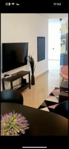 a living room with a flat screen tv and a table at Vacation in the heart of the city netanya in Netanya