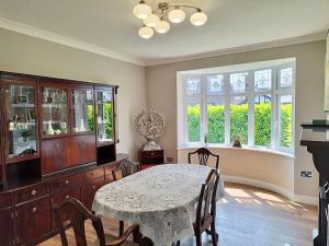 a dining room with a table and some windows at Cosy Modern Grimsby Home in Great Coates