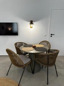 uma mesa e cadeiras com uma televisão num quarto em Koutsounos em Kythnos