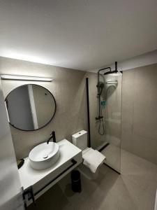 a bathroom with a sink and a mirror and a shower at Koutsounos in Kithnos