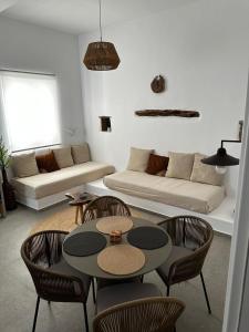 uma sala de estar com uma mesa e cadeiras e um sofá em Koutsounos em Kythnos