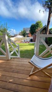 une chaise à bascule blanche assise sur une terrasse en bois dans l'établissement Chantemerle à partir de 2 personnes, à Villers-sur-Mer