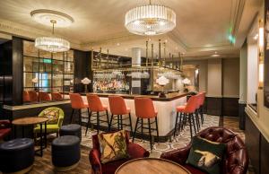 eine Bar in der Hotellobby mit Stühlen und einer Theke in der Unterkunft Sloane Place in London