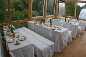 a row of tables with white tablecloths and plates at Gutshaus mit Seeblick - ökologisch & nachhaltig in Lübow