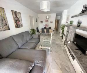 a living room with a couch and a television at Doña Julia Golf in Casares