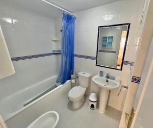 a white bathroom with a toilet and a sink at Doña Julia Golf in Casares