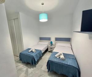 a room with two beds and a blue light at Doña Julia Golf in Casares +5 photos