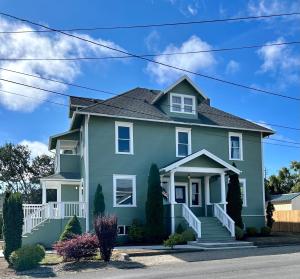 a green house with a gray roof at The Pearl Inn Bed and Breakfast in Ilwaco