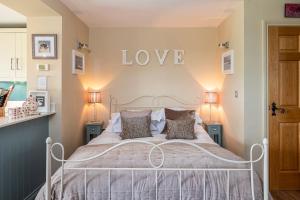 a bedroom with a bed with a love sign on the wall at Esk View Retreat in Whitby
