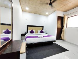 a bedroom with a bed with purple pillows and a mirror at PerfectStayz Mussoorie Hills in Mussoorie